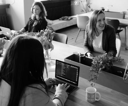 Office workers having a conversation at a shared table